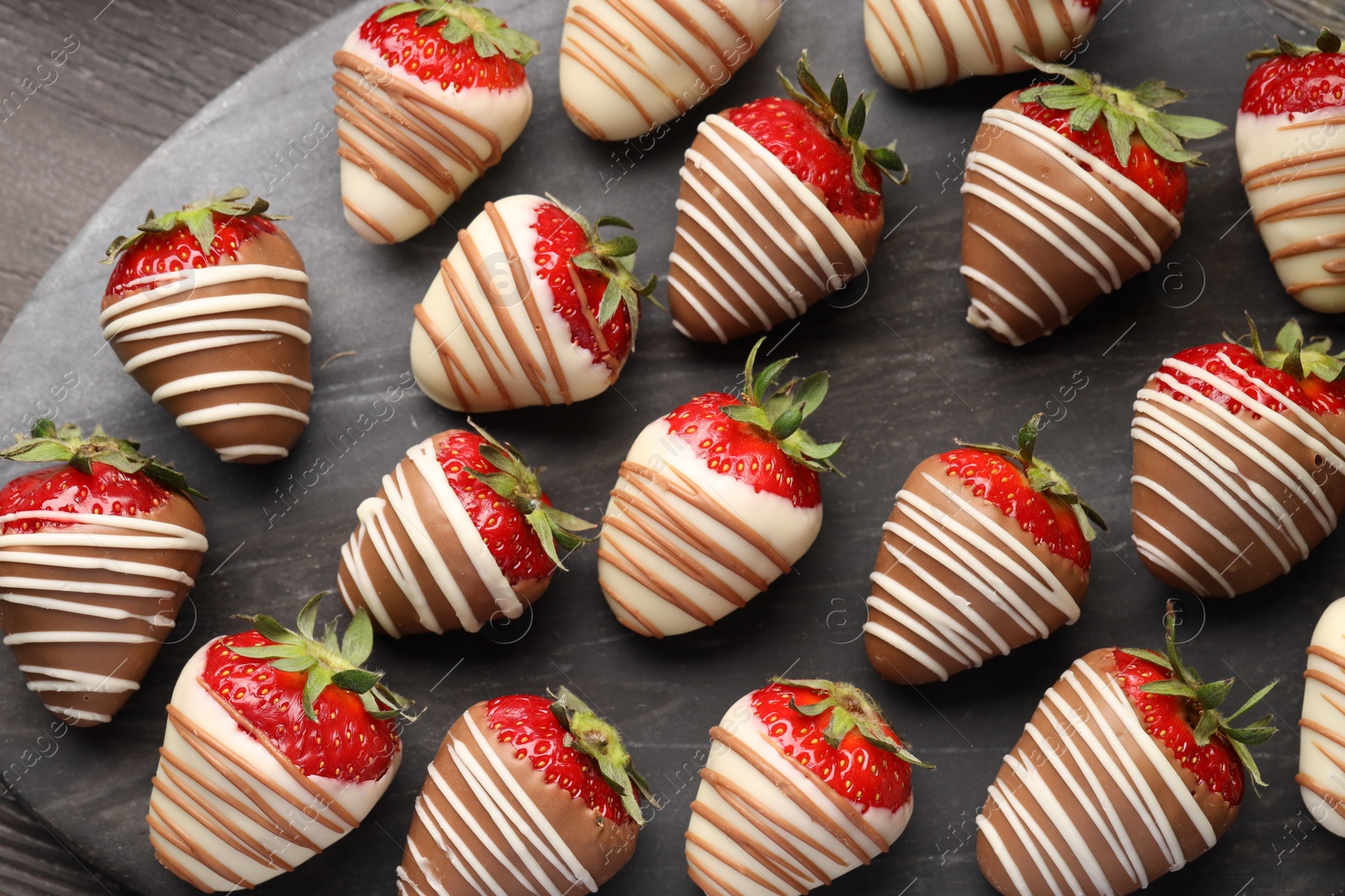 Photo of Delicious chocolate covered strawberries on wooden table, top view