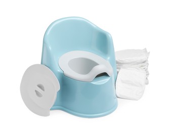 Photo of Light blue baby potty and stack of diapers isolated on white. Toilet training