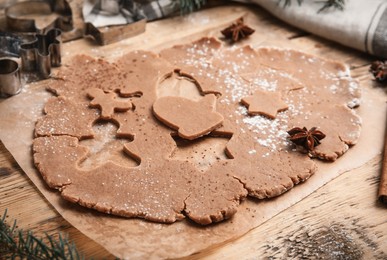 Photo of Making Christmas cookies. Raw dough and cutters on wooden table