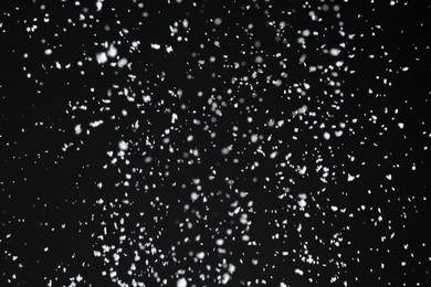 Photo of White snow falling down on black background