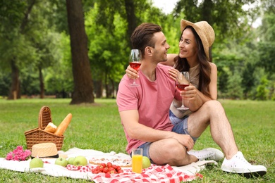 Photo of Happy young couple having picnic in park on summer day