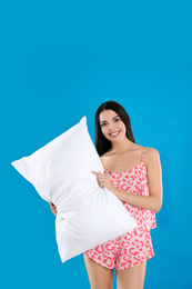 Photo of Young woman with pillow on blue background