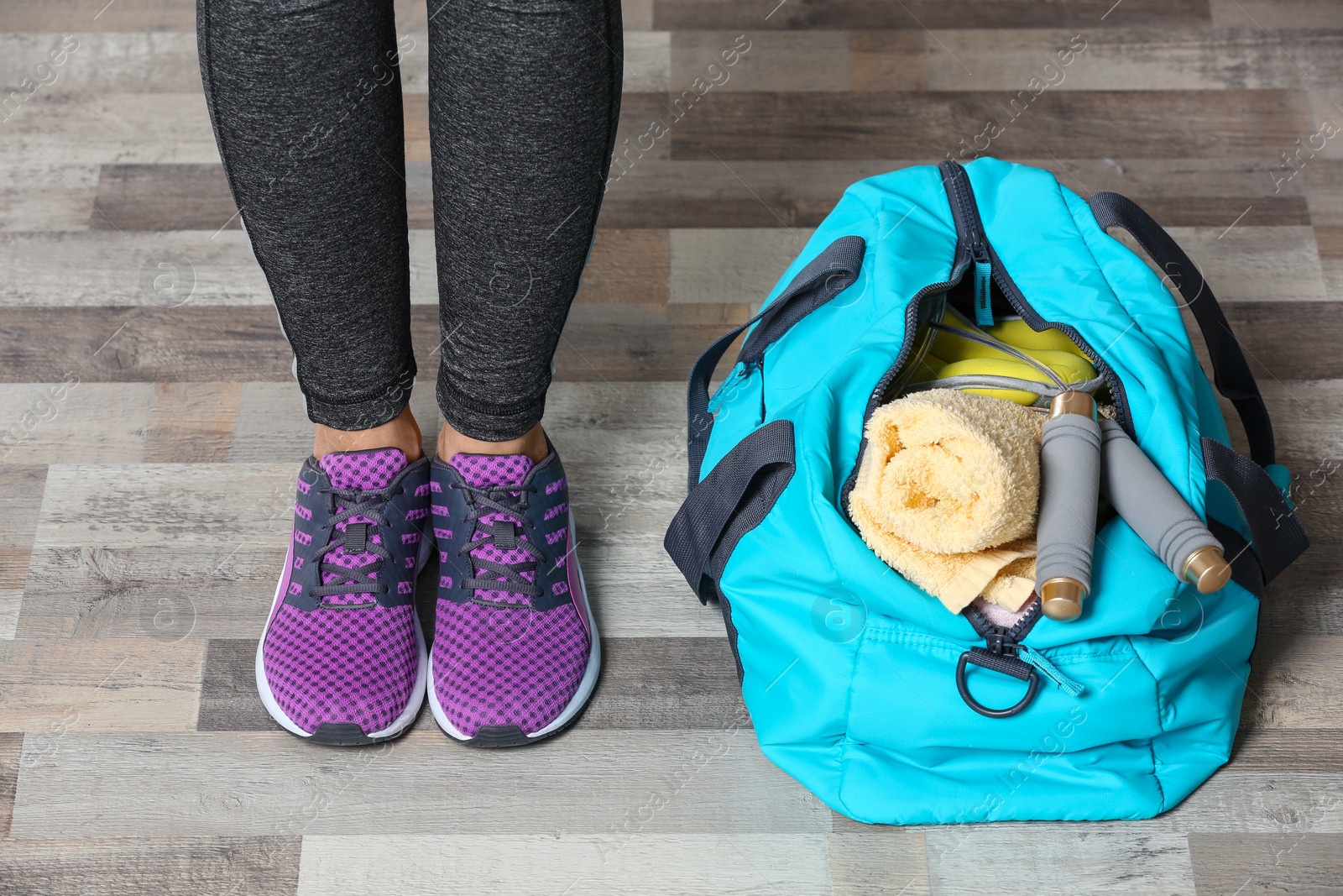 Photo of Young woman standing near sports bag, closeup