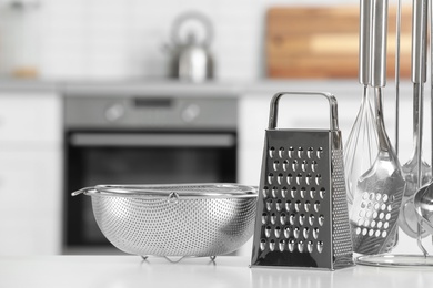 Photo of Set of clean utensils on table in kitchen. Space for text
