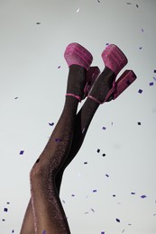 Photo of Stylish party. Woman wearing pink high heeled shoes with platform and square toes on light grey background, closeup