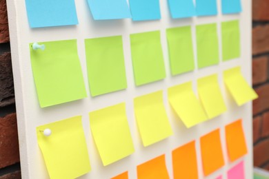 Photo of Blank colorful paper notes on white board, closeup