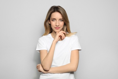 Photo of Portrait of young woman with beautiful face on grey background