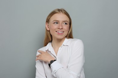 Photo of Portrait of beautiful young woman in white shirt on grey background