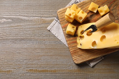 Photo of Tasty fresh cheese on wooden table, top view. Space for text