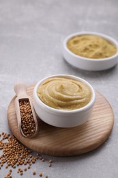 Photo of Delicious mustard and seeds on light grey table