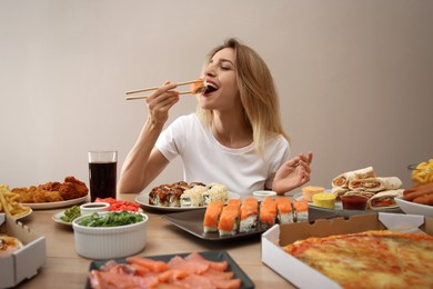 Photo of Food blogger eating at table against beige background. Mukbang vlog