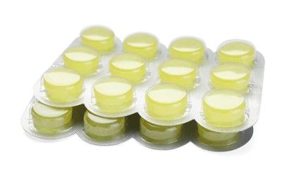Photo of Blisters with yellow cough drops on white background