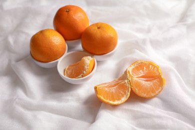 Photo of Fresh tasty ripe tangerines on white cloth