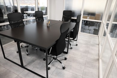 Photo of Comfortable office chairs and tables in meeting room