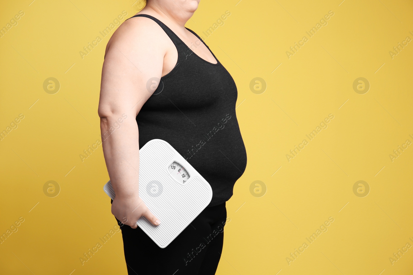 Photo of Overweight woman with scales on color background