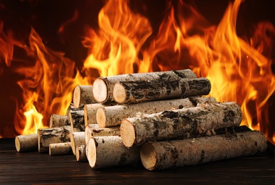 Image of Dry wood and burning fire on background. Cozy atmosphere