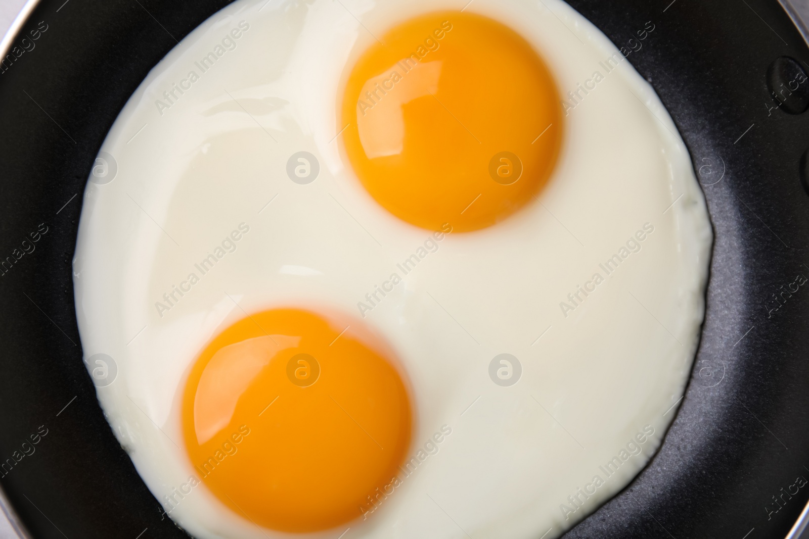 Photo of Tasty fried eggs in pan, top view