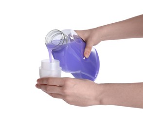 Photo of Woman pouring fabric softener from bottle into cap on white background, closeup