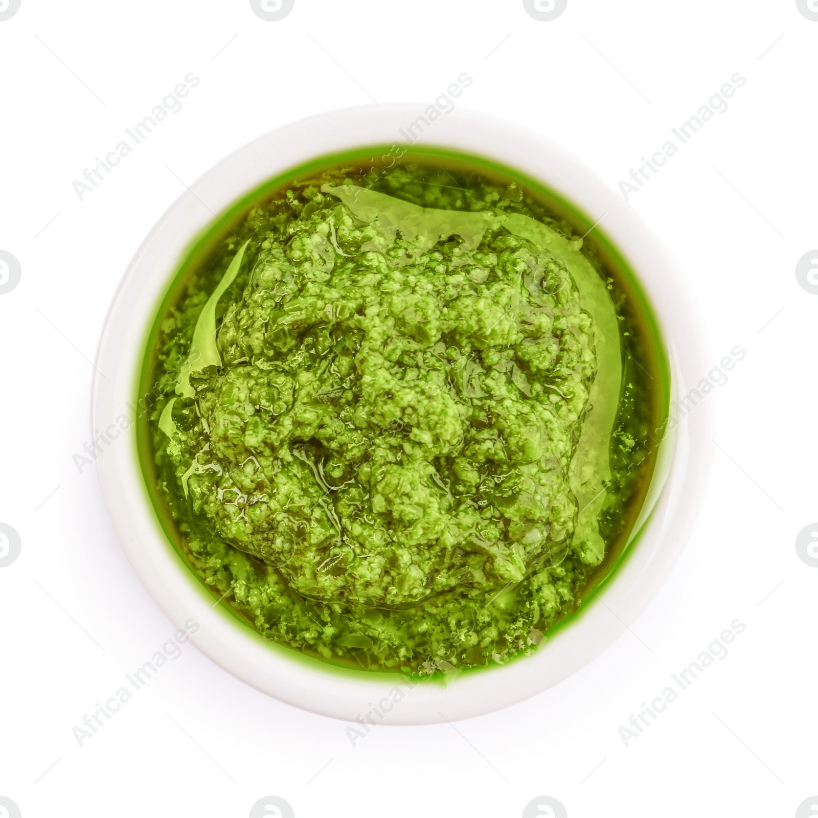 Photo of Bowl of tasty pesto sauce isolated on white, top view