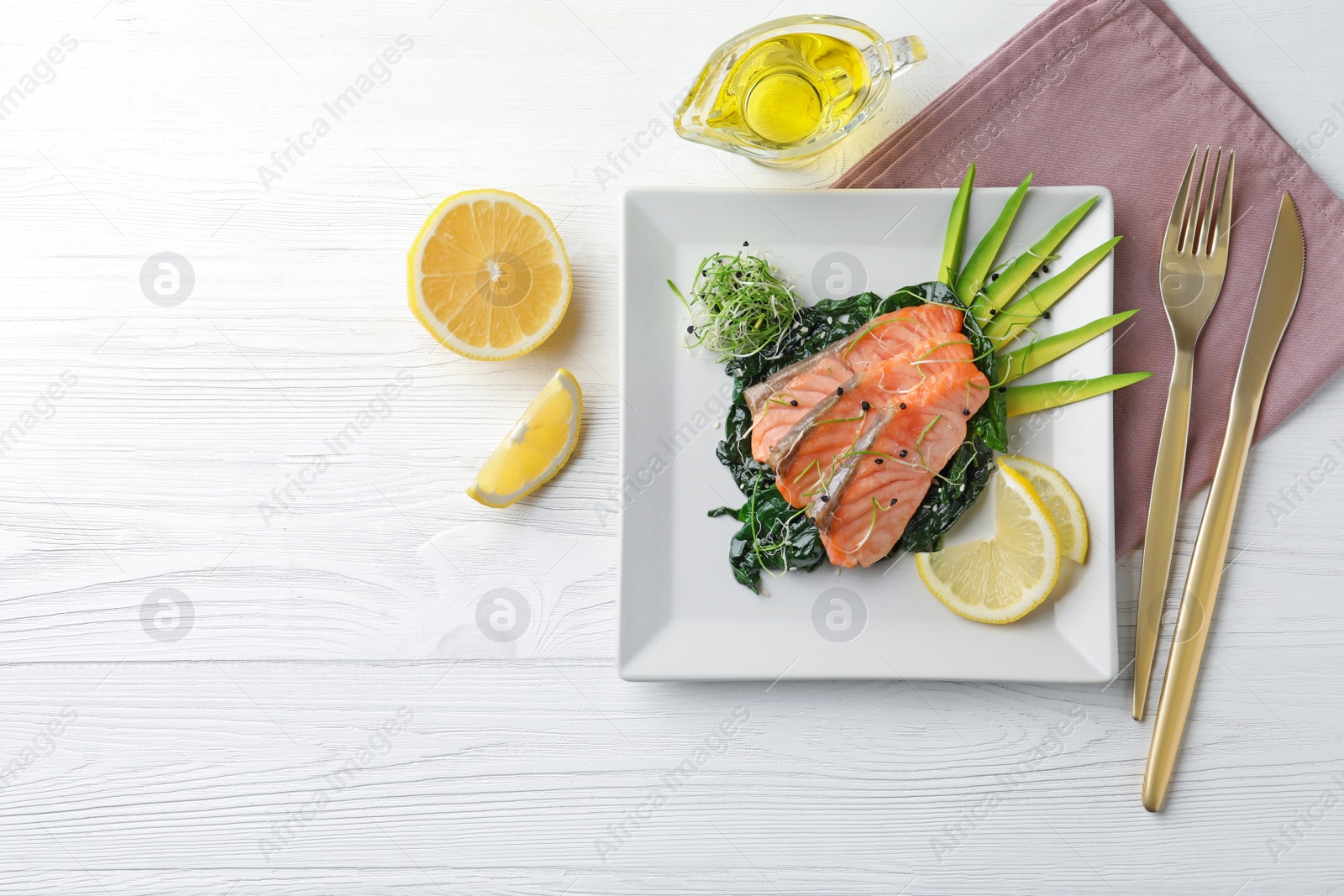 Photo of Tasty salmon with spinach served on white wooden table, flat lay