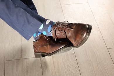 Man wearing stylish shoes and colorful socks indoors, closeup