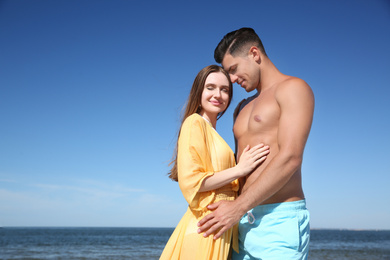 Beautiful woman and her boyfriend on beach. Happy couple