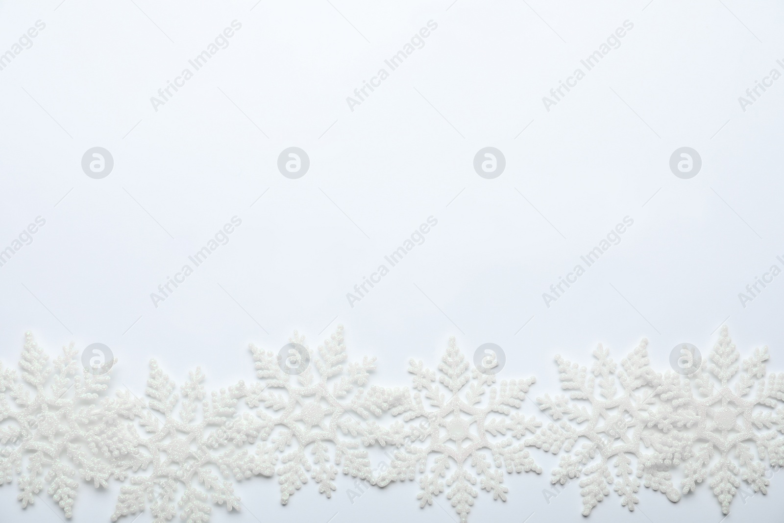 Photo of Beautiful decorative snowflakes on white background, flat lay. Space for text