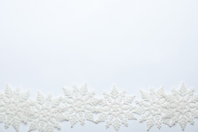 Beautiful decorative snowflakes on white background, flat lay. Space for text