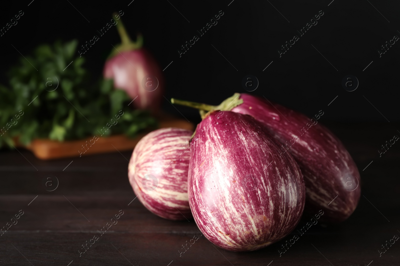 Photo of Ripe purple eggplants on wooden table, closeup