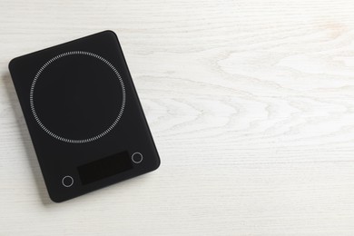 Photo of Modern digital kitchen scale on white wooden table, top view. Space for text