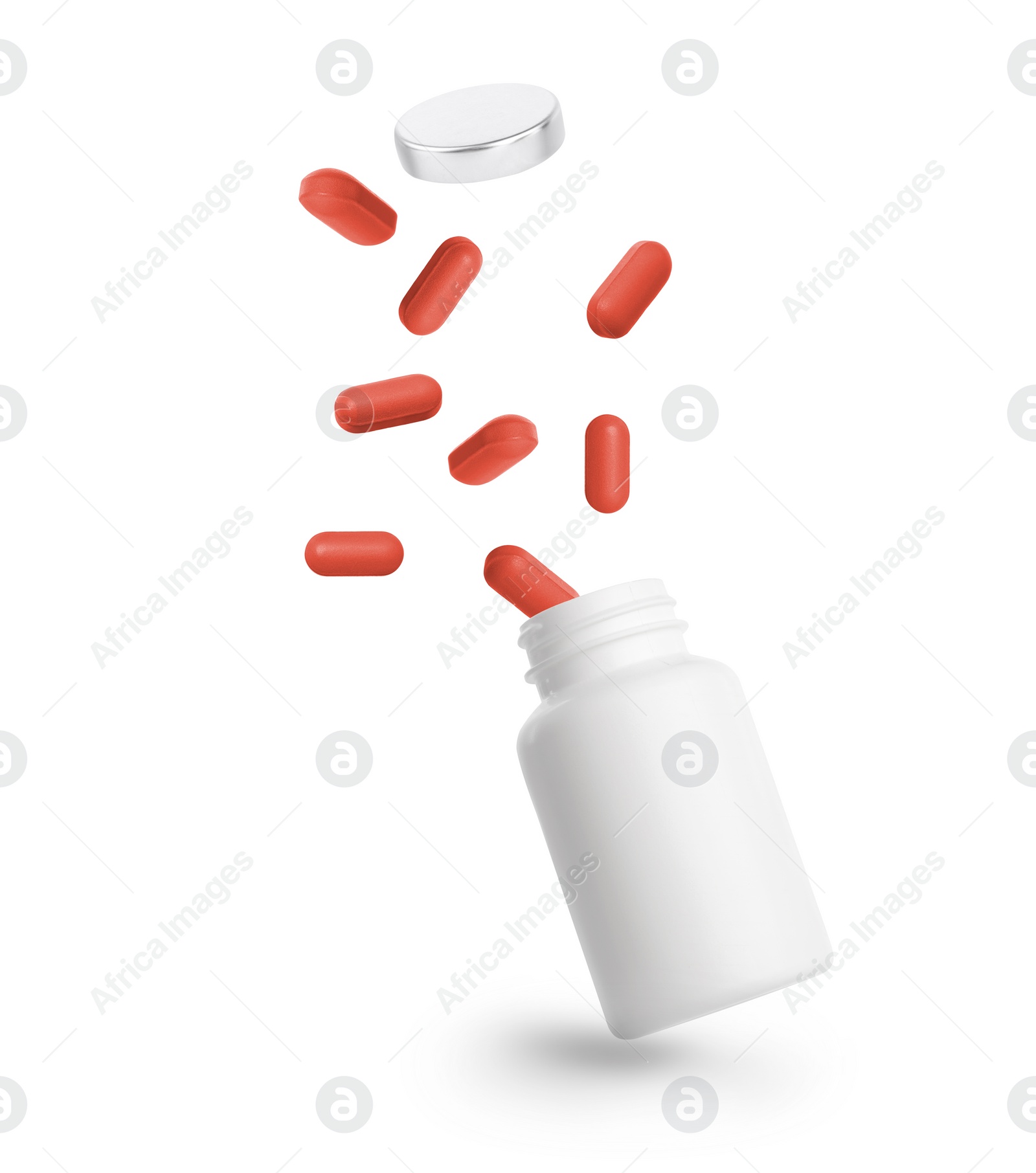 Image of Vitamin pills and bottle in air against white background