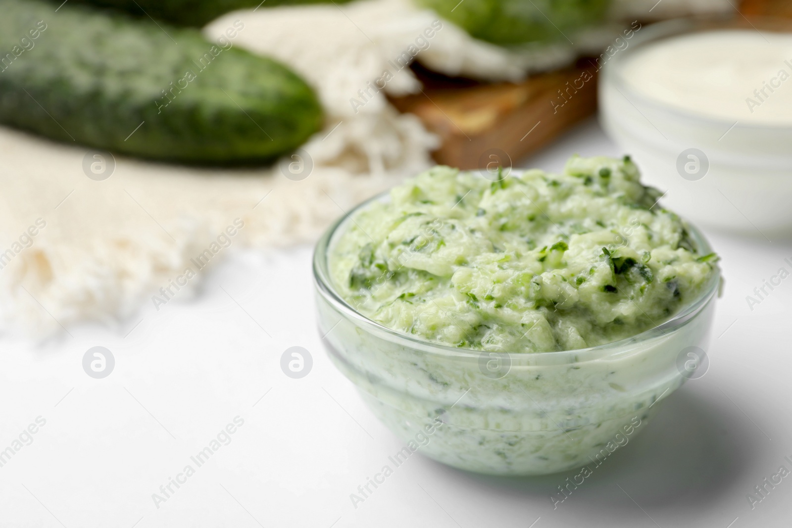 Photo of Handmade cucumber face mask in glass bowl on white table