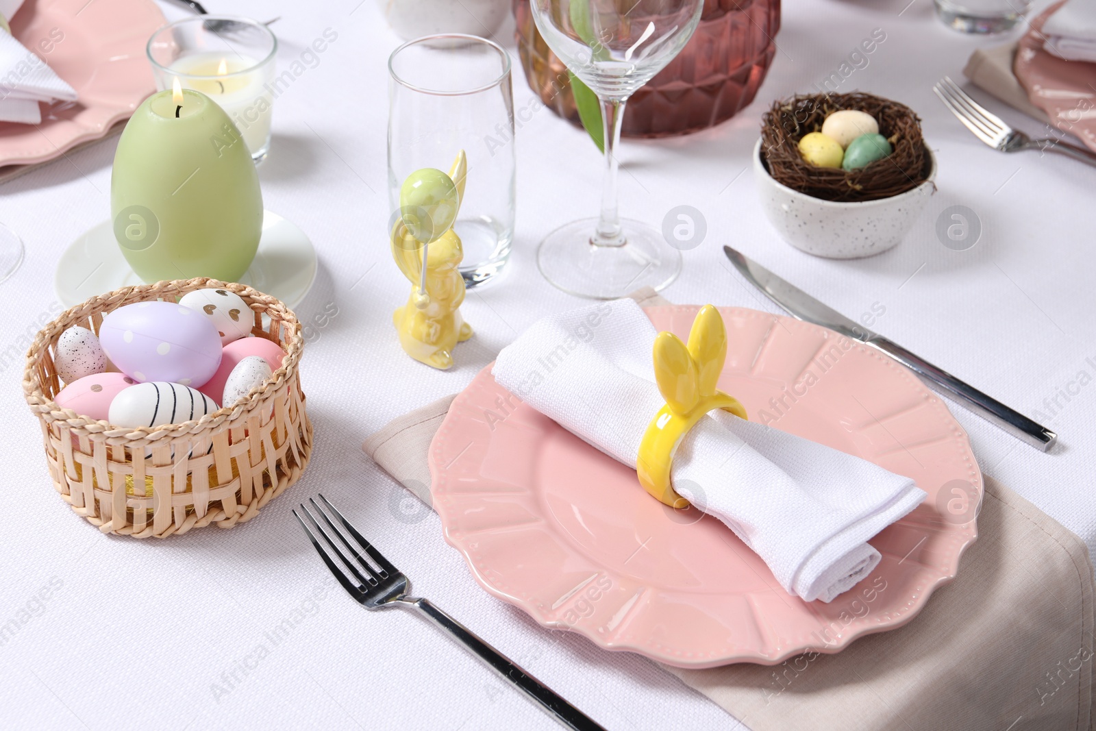 Photo of Festive table setting with napkin ring in shape of bunny ears. Easter celebration