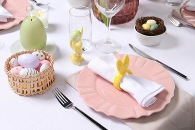 Photo of Festive table setting with napkin ring in shape of bunny ears. Easter celebration