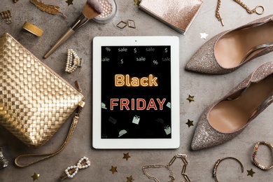 Photo of Flat lay composition with tablet and stylish accessories on grey background. Black Friday sale