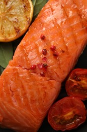 Photo of Plate with tasty grilled salmon, tomatoes, lemon and basil, top view