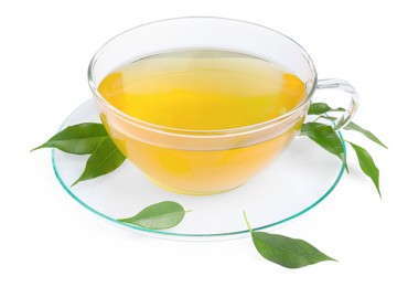 Photo of Fresh green tea in glass cup, leaves and saucer isolated on white