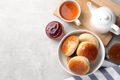 Tasty scones prepared on soda water, jam and tea on grey marble table, flat lay. Space for text