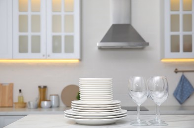 Set of clean dishes and glasses on table in stylish kitchen