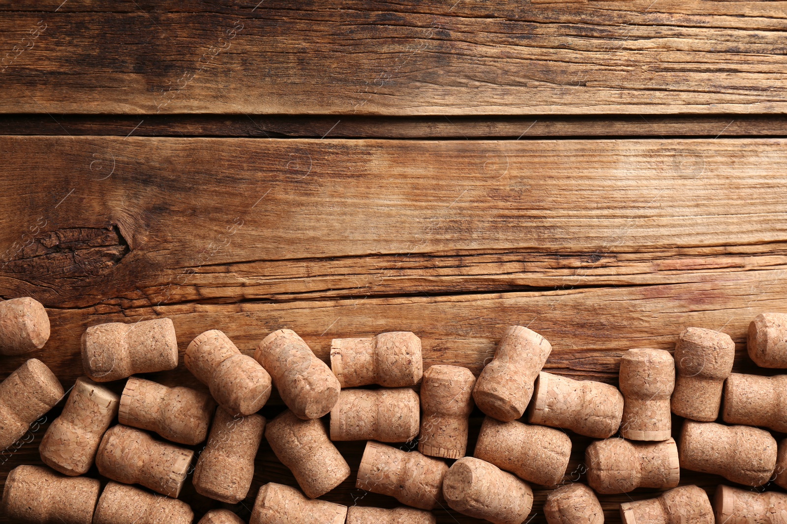 Photo of Sparkling wine bottle corks on wooden table, flat lay. Space for text