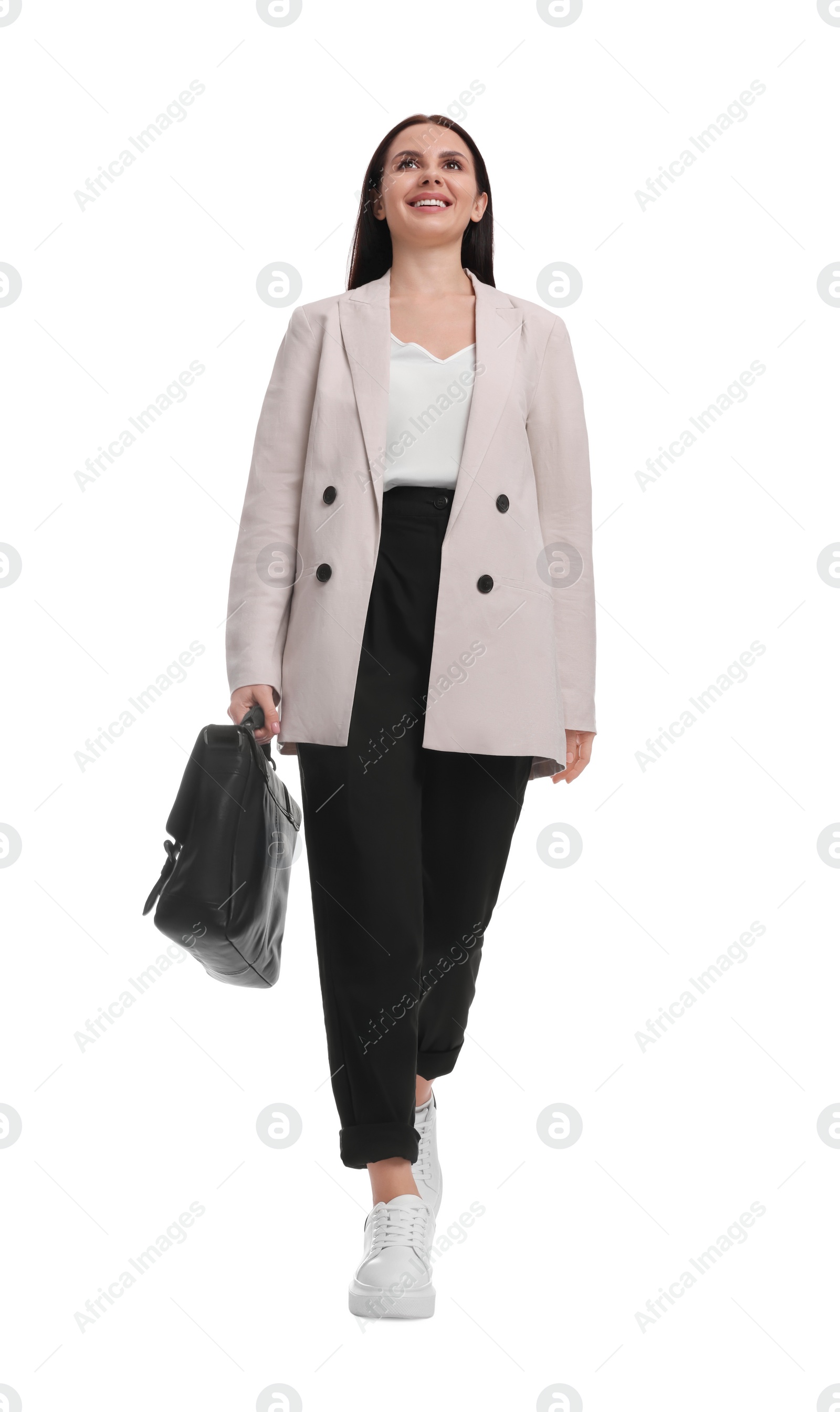 Photo of Beautiful businesswoman in suit with briefcase walking on white background, low angle view