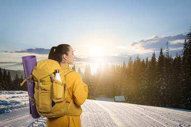 Happy tourist with backpack in snowy mountains