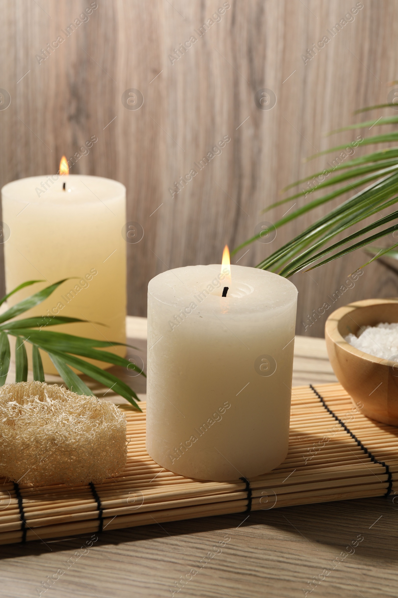 Photo of Composition with spa supplies and palm leaves on wooden table