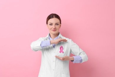 Photo of Mammologist with pink ribbon on color background. Breast cancer awareness