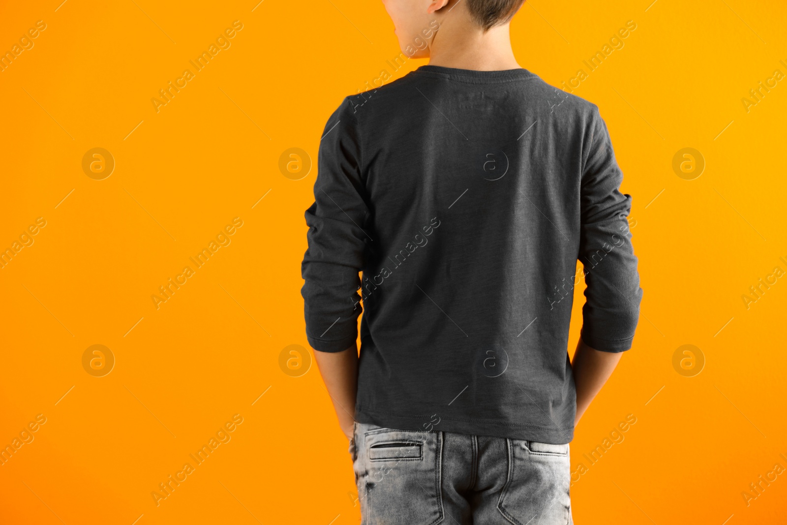 Photo of Little boy in long sleeve t-shirt on color background. Mock-up for design