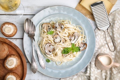 Delicious pasta with mushrooms and cheese served on white wooden table, flat lay
