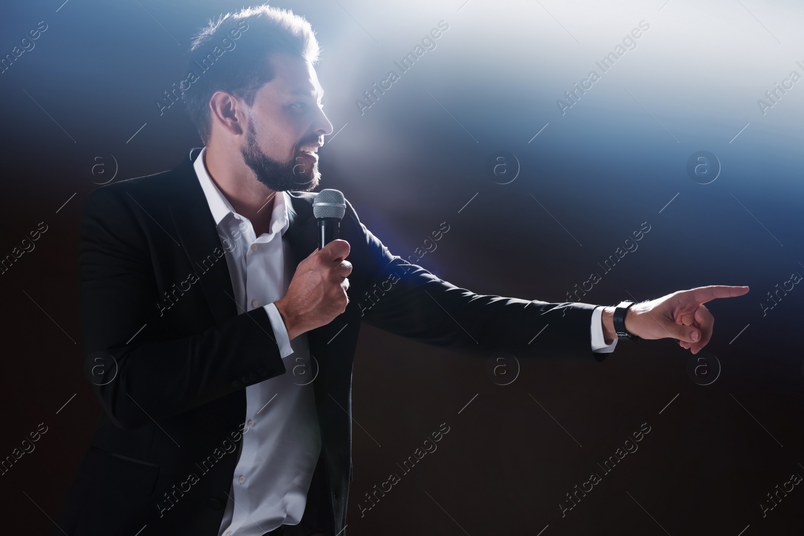 Photo of Motivational speaker with microphone performing on stage