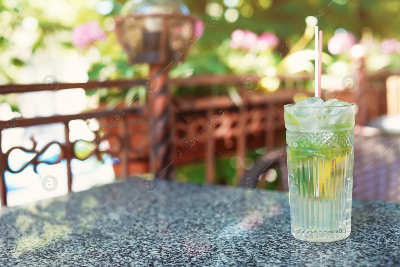 Photo of Refreshing tasty lemonade with mint and lemon in glass on table. Natural detox drink