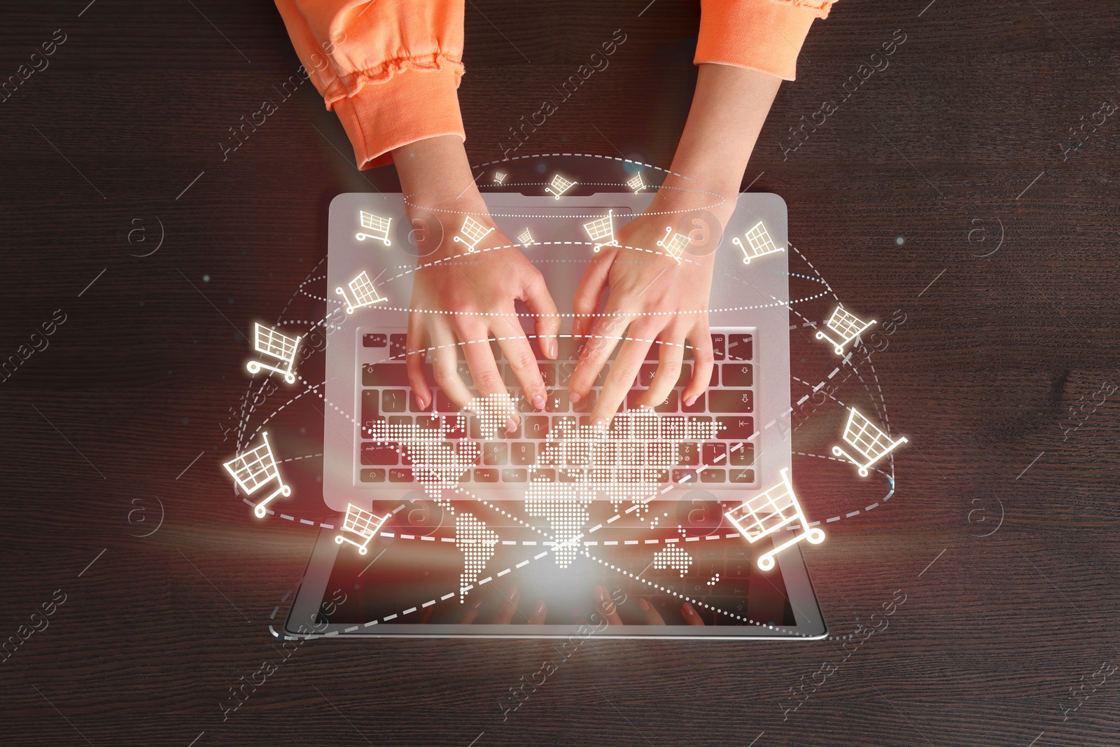 Image of Woman using laptop for online purchases at table, top view. Illustration of world map and shopping cart icons above device