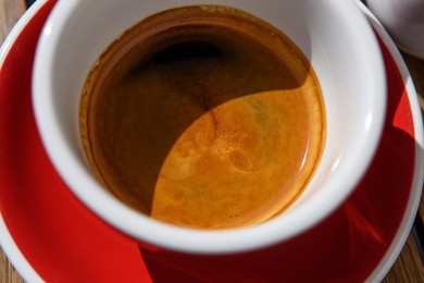 Photo of Above view of cup with aromatic hot coffee, closeup